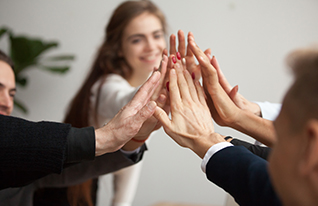 Group of motivated business people giving each other a high five